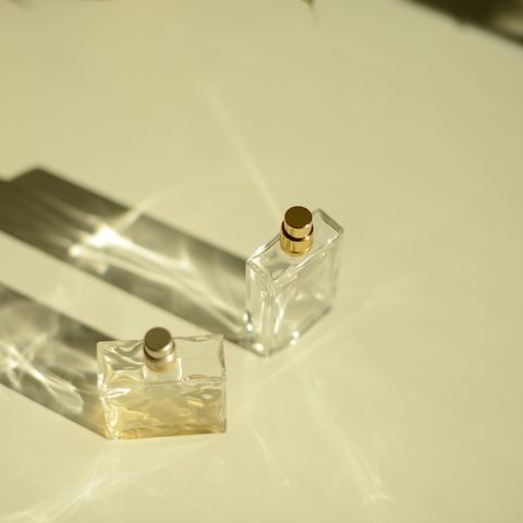 two perfume bottles on white shelf