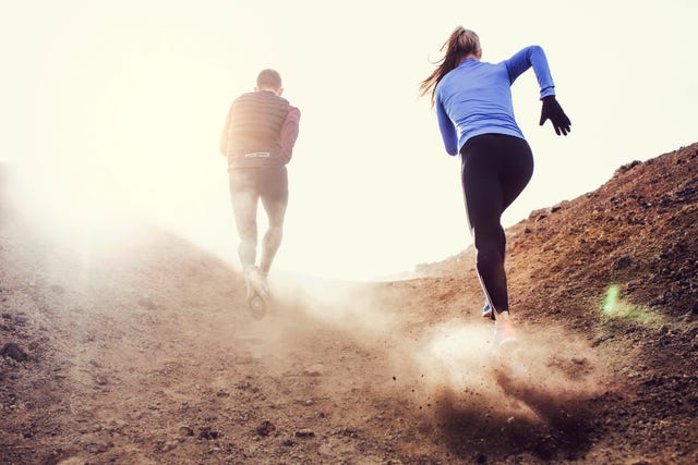 two runners blazing a trail up a rocky hilly path
