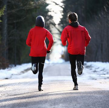 two runners on forest road in winter