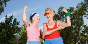 two senior adult women exercising in park