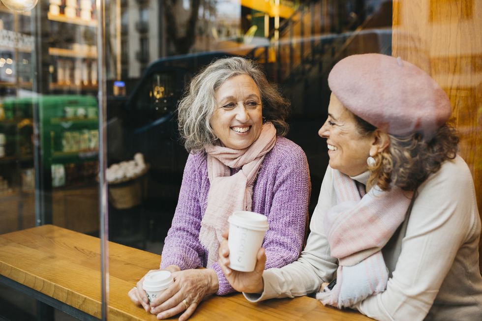 two senior women drinking coffee in a coffee shop