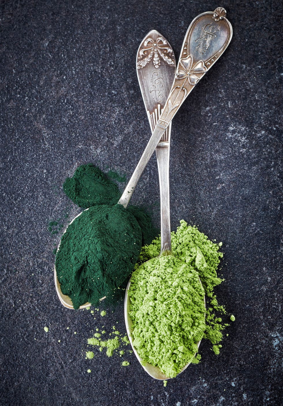 Two spoons of spirulina algae and wheat sprouts powder
