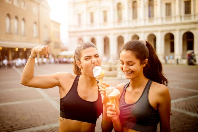 two sporty women eating ice cream.