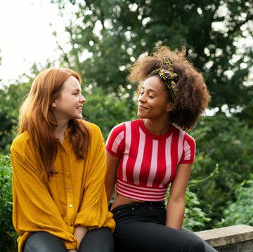 two women sat on wall