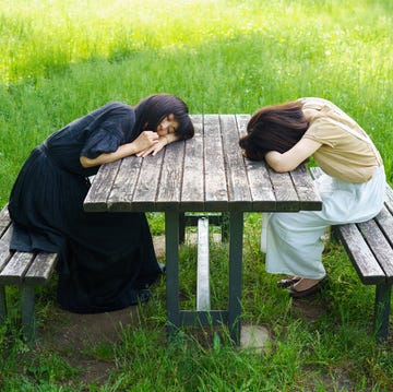 twee vrouwen die slapen op een picknickbankje in het park