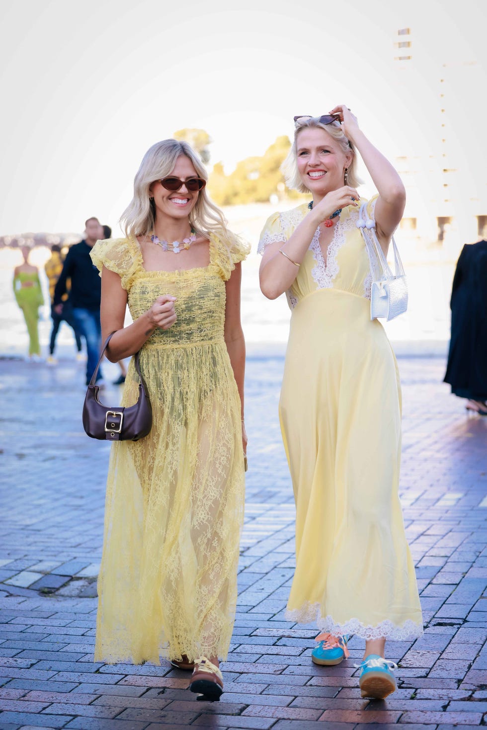 two women wearing dresses and trainers