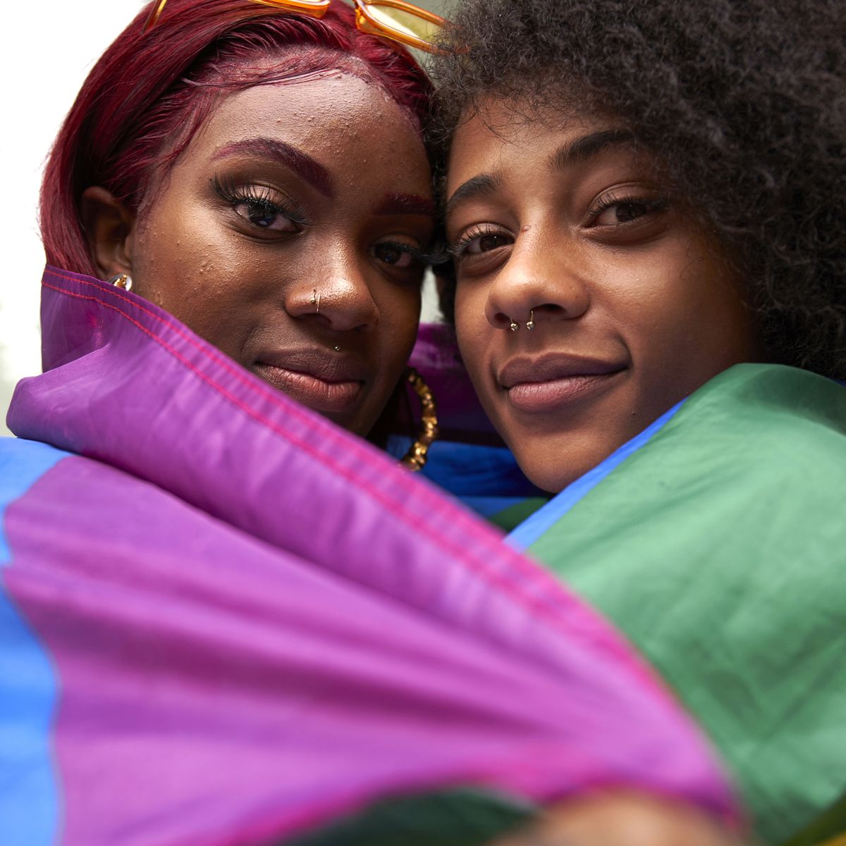 two women wrapped in pride flag