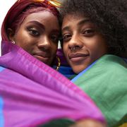 two women wrapped in pride flag