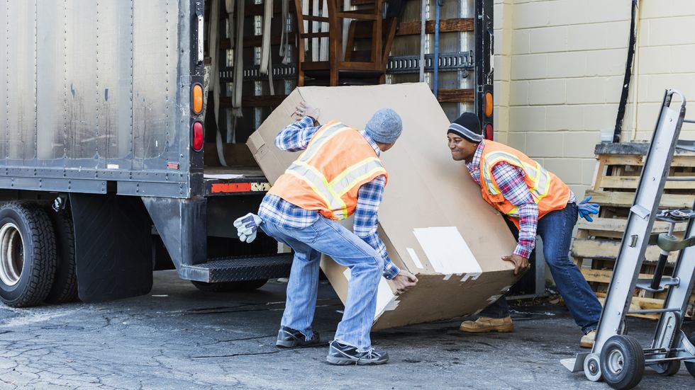 two workers with a truck, moving large box