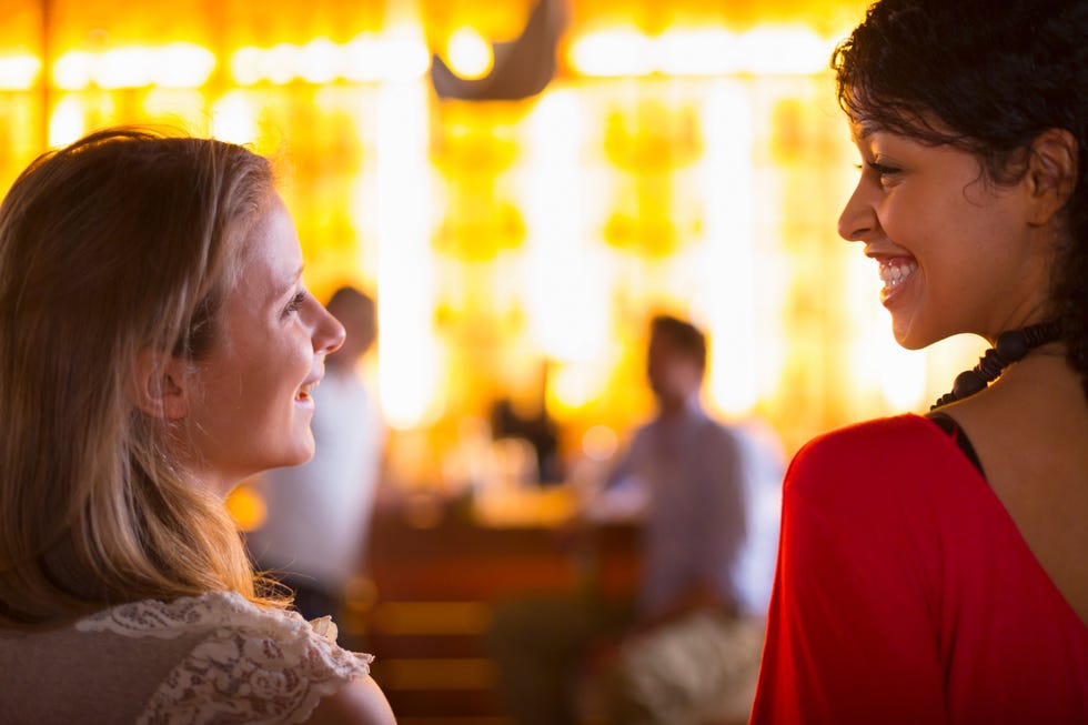 two young females talking in bar