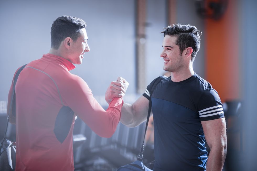 Two young men shaking hands in gym