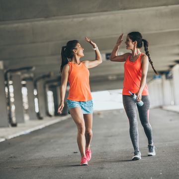 two young woman giving high five to each other