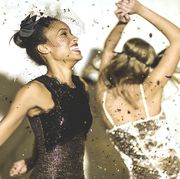 two young women dancing with confetti falling