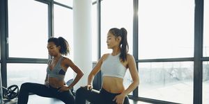 two young women exercising in gym, doing lunges
