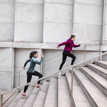 two young women running up stairs in the city