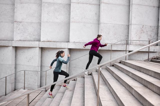 two young women running up stairs in the city