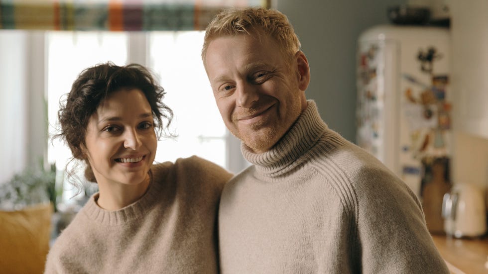 two individuals standing together in a cozy kitchen setting