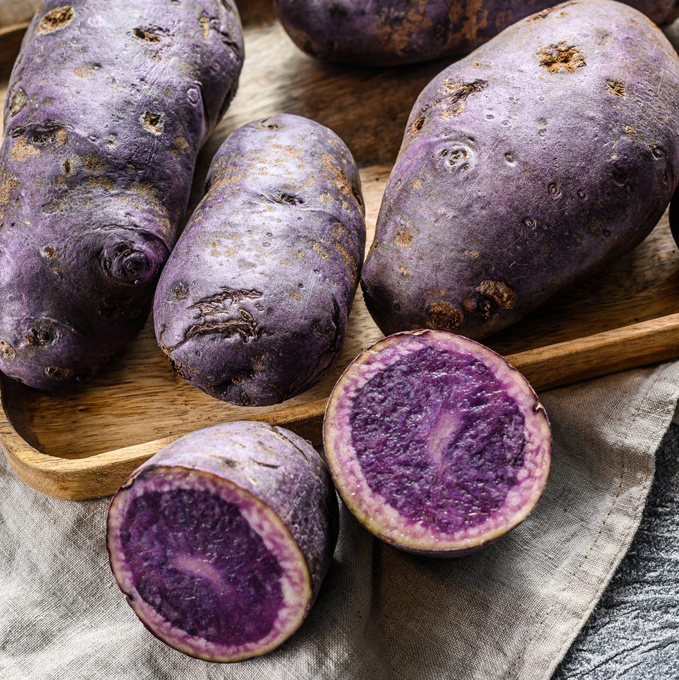 vitelotte raw potato on a chopping board gray background top view