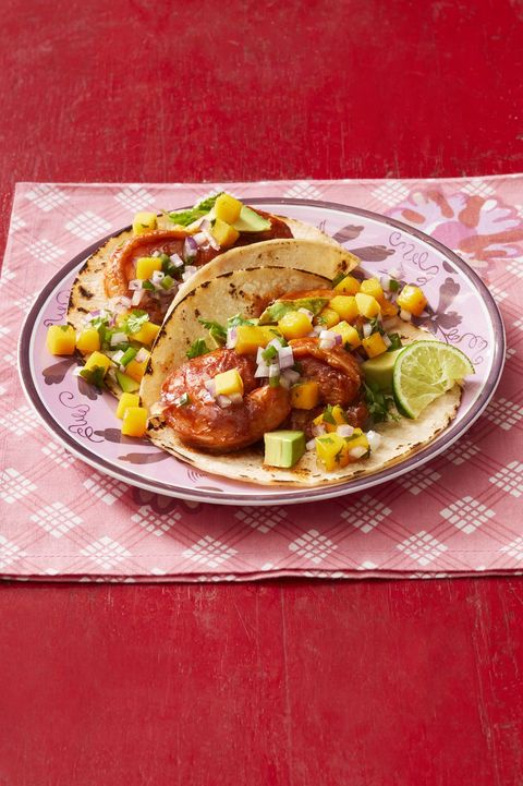 shrimp tacos with mango salsa and lime on red plate