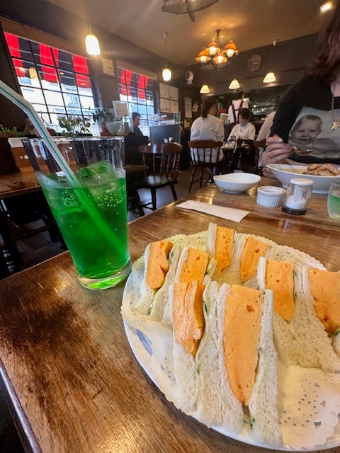 a refreshing beverage and a plate of colorful sandwiches in a dining setting