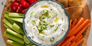 creamy tzatziki topped with oil and cucumbers, served with pita and veggies