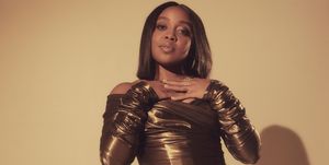 quinta brunson wears a bronze dress and poses for the camera