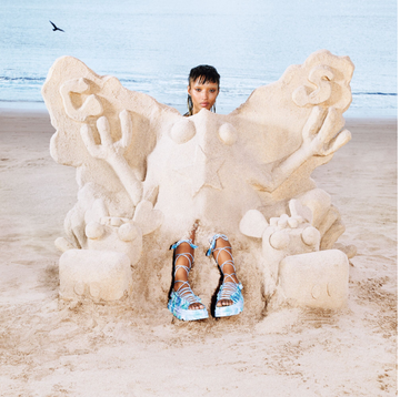 a person sitting on a sand castle
