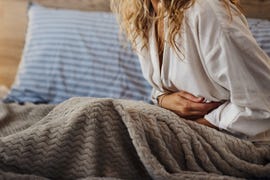 madre con dolor de tripa en el sofá