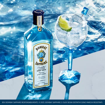 Bombay Sapphire bombay sapphire gin bottle and a gin cocktail on a marble surface next to water