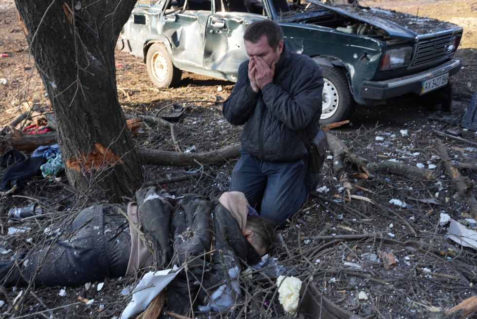 kharkiv, ukraine   february 24 editors note image depicts death a man mourns near a body as airstrike damages an apartment complex outside of kharkiv, ukraine on february 24, 2022 photo by wolfgang schwananadolu agency via getty images