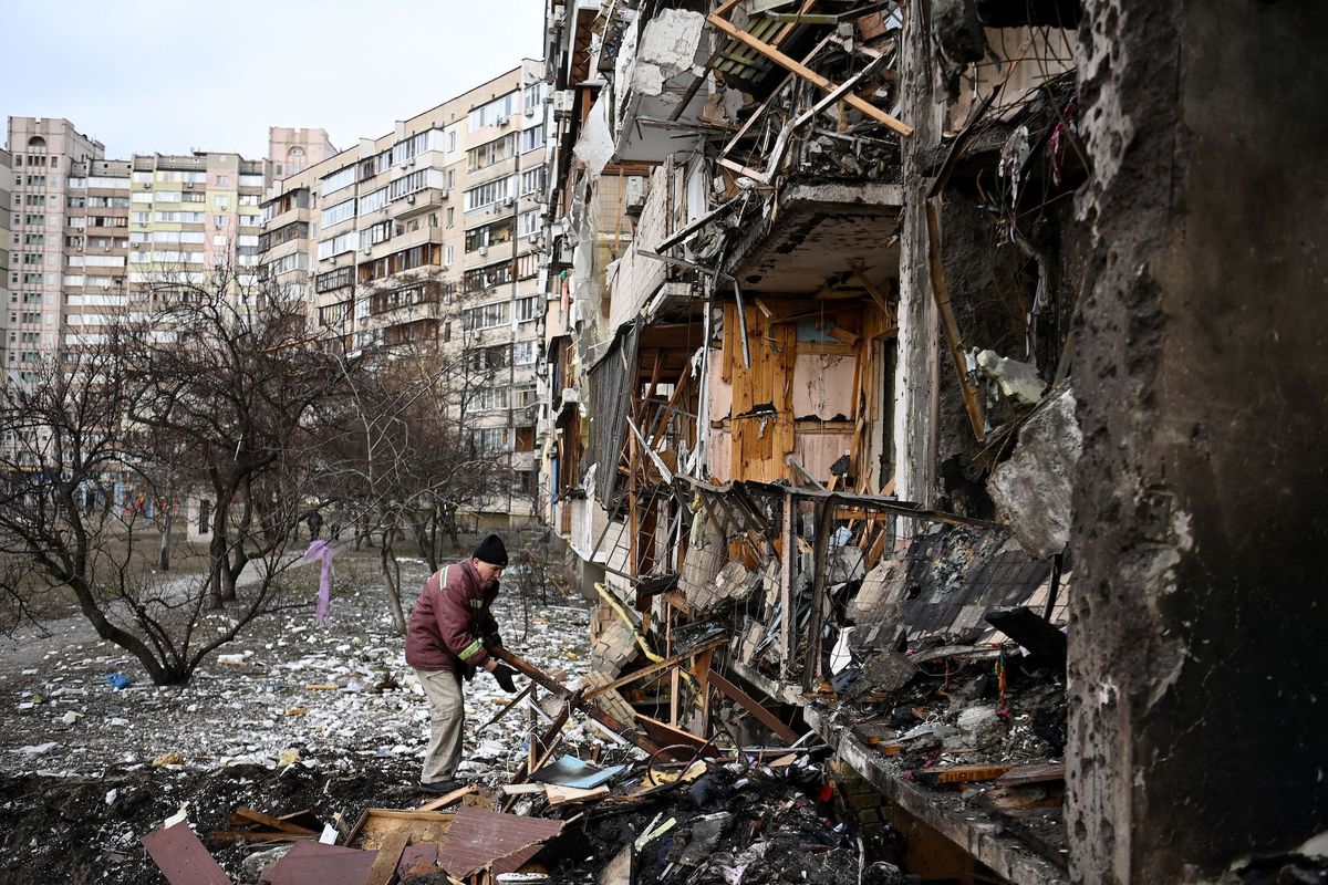 topshot   a man clears debris at a damaged residential building at koshytsa street, a suburb of the ukrainian capital kyiv, where a military shell allegedly hit, on february 25, 2022   russian forces reached the outskirts of kyiv on friday as ukrainian president volodymyr zelensky said the invading troops were targeting civilians and explosions could be heard in the besieged capital pre dawn blasts in kyiv set off a second day of violence after russian president vladimir putin defied western warnings to unleash a full scale ground invasion and air assault on thursday that quickly claimed dozens of lives and displaced at least 100,000 people photo by daniel leal  afp photo by daniel lealafp via getty images