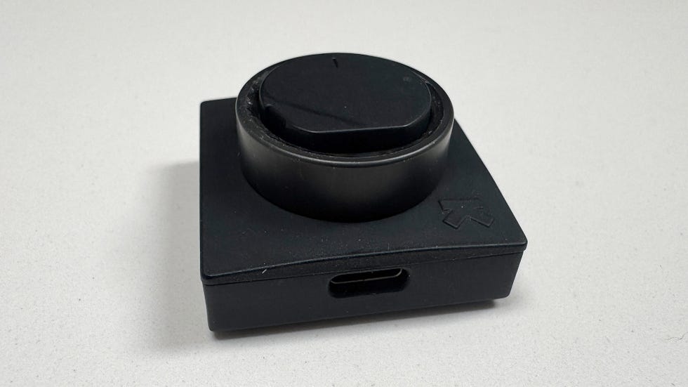 a black smart ring sat in a black charging dock