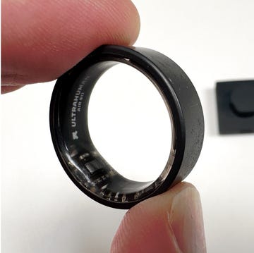 a person wearing and holding a black smart ring a person wearing and holding a black smart ring