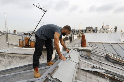 a french roofer works on august 24, 2017 on a zinc roof of a paris' building