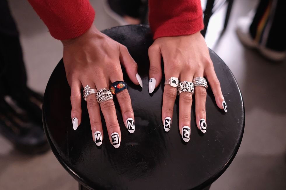 a person's hands with rings on them