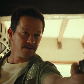 uncharted movie screenshot of mark wahlberg pointing a gun as sully, sporting a mustache