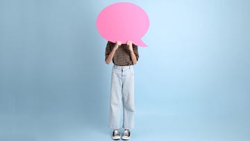 teenage girl standing behind pink speech bubble