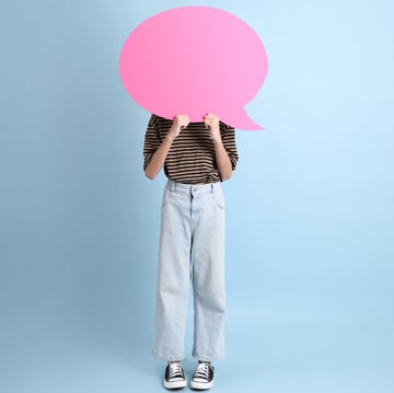 teenage girl standing behind pink speech bubble teenage girl standing behind pink speech bubble