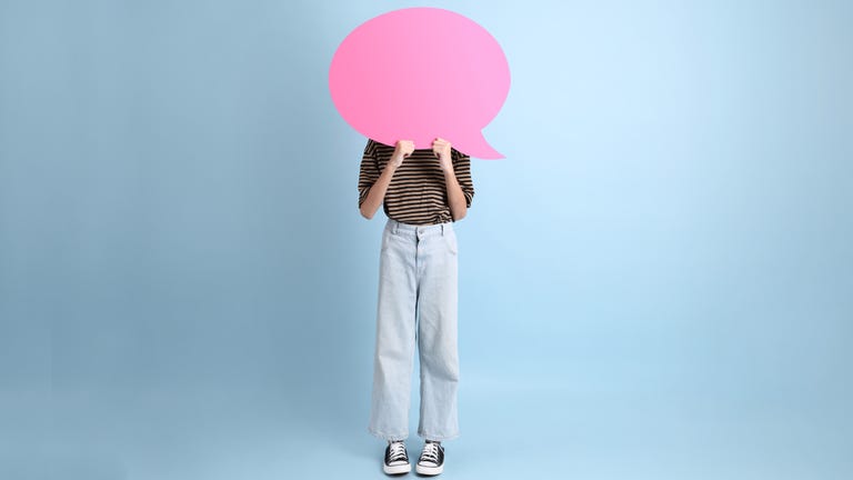 teenage girl standing behind pink speech bubble