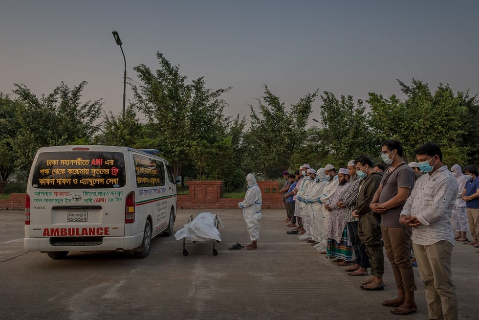 Dhaka, Bangladesh DHAKA BANGLADESHOp de begraafplaats van Rayer Bazar in Dhaka Bangladesh spreekt Farid het islamitische begrafenisgebed janazah uit voor een COVID19slachtoffer en voor verwanten die de begrafenis bijwonen In Bangladesh werd deze begraafplaats in april 2020 officieel aangewezen als de plek waar slachtoffers van de pandemie moesten worden begraven