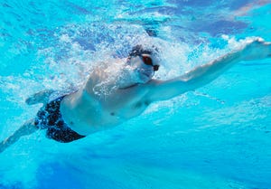 underwater shot of professional male athlete swimming in pool