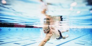 underwater view of mature male athlete swimming during morning workout