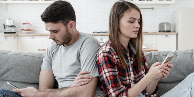 Unhappy couple ignoring each other using mobile phones. Boyfriend and girlfriend with smartphone addiction. Bad relationship concept