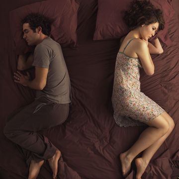 unhappy couple sleeping in bed