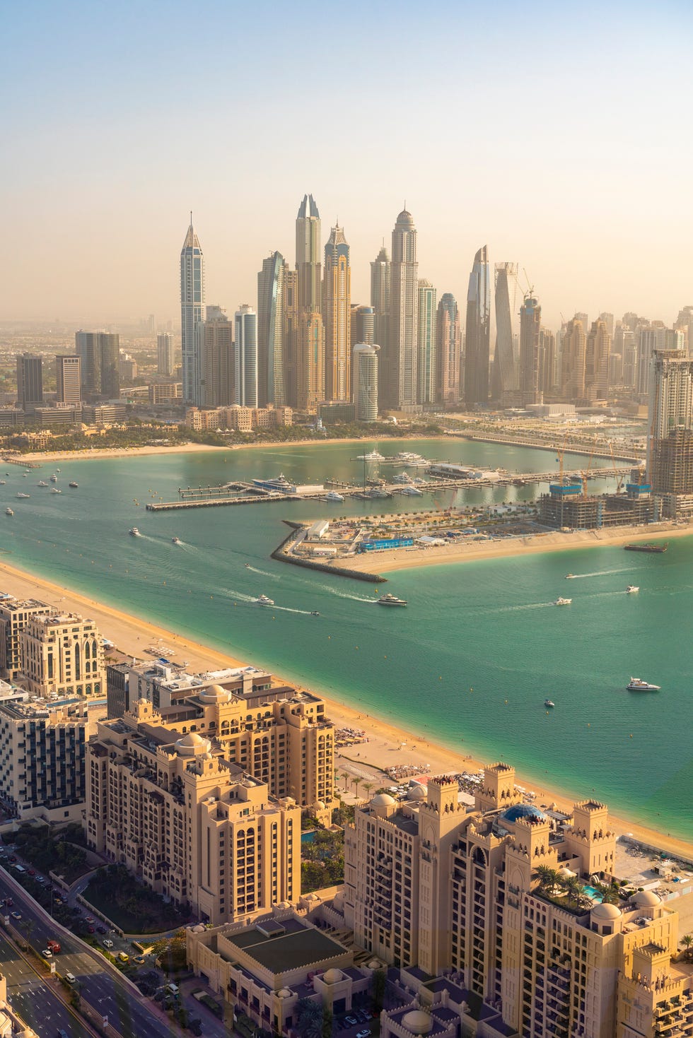 united arab emirates, dubai, buildings of palm jumeirah with marina and downtown skyscrapers in background