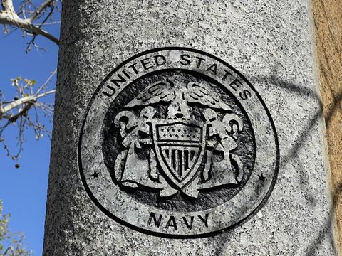 the us navy logo etched into a stone pillar