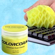 neon yellow gel dust cleaner in jar and on black key board, light blue background