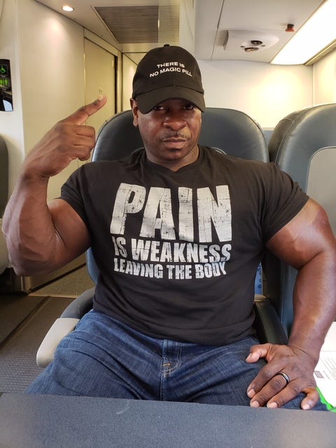 Arm, Muscle, T-shirt, Shoulder, Sitting, Cool, Hand, Facial hair, Chest, Abdomen, 