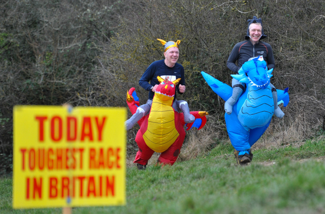 Participants in inflatable dragon costumes racing outdoors