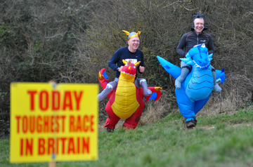 Participants in inflatable dragon costumes racing outdoors